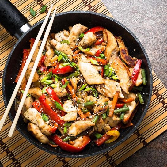 Simple chicken stir fry in wok with chopsticks