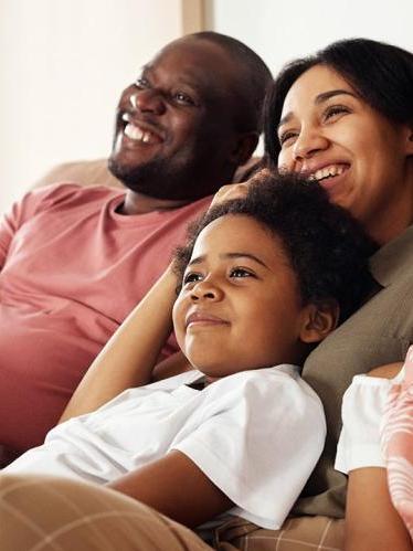 Family on couch watching television