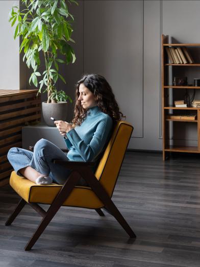 Woman sitting in chair shopping on her smartphone