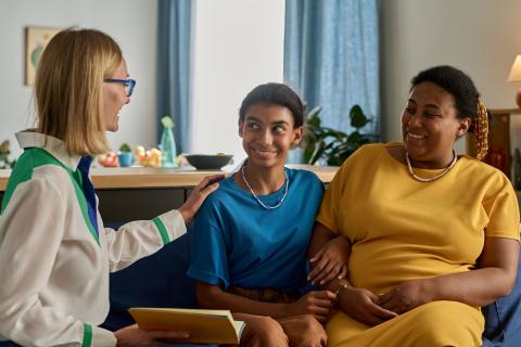 African American mother and daughter talking to social worker