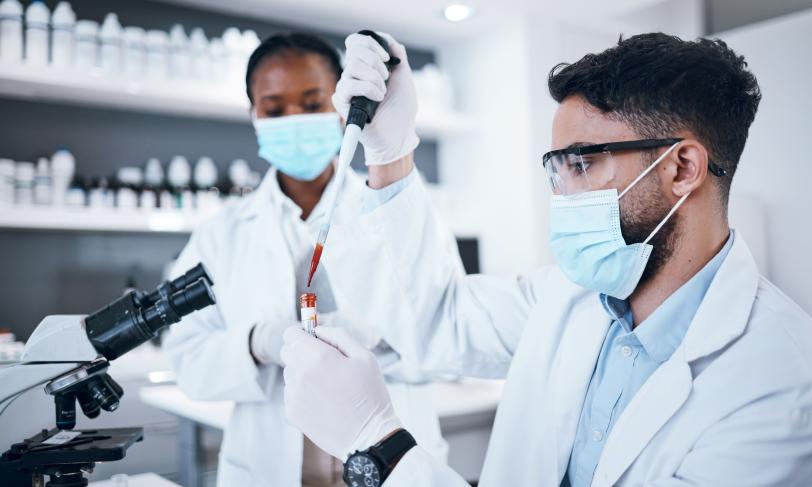 scientific research team testing vial of blood in laboratory