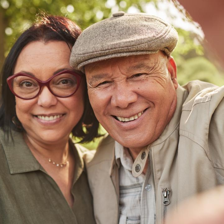 Smiling senior couple taking selfie in a park