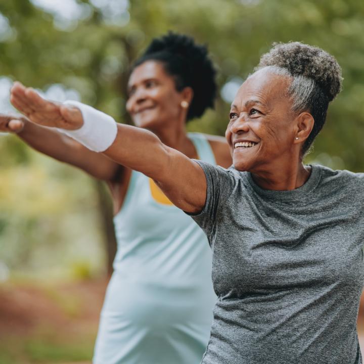 Senior African American women doing stretches outdoors