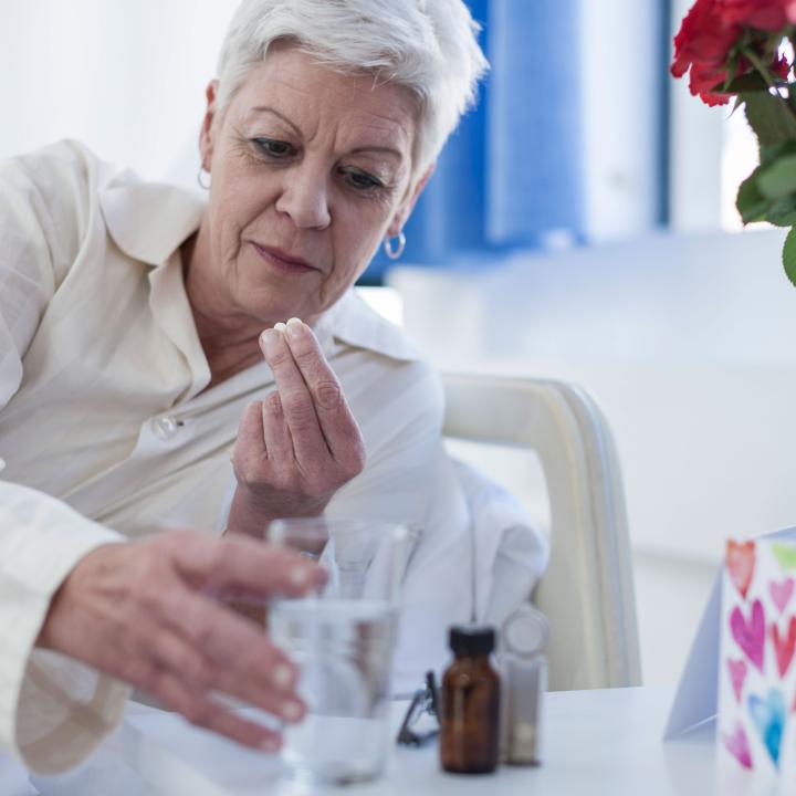 Senior woman in bed taking medication