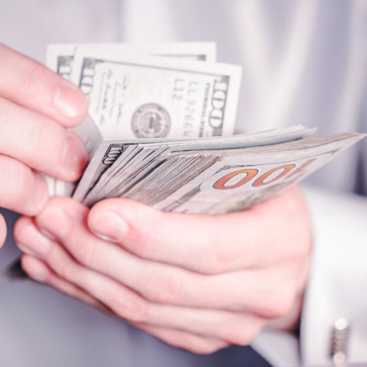 A man holding Dollars bill