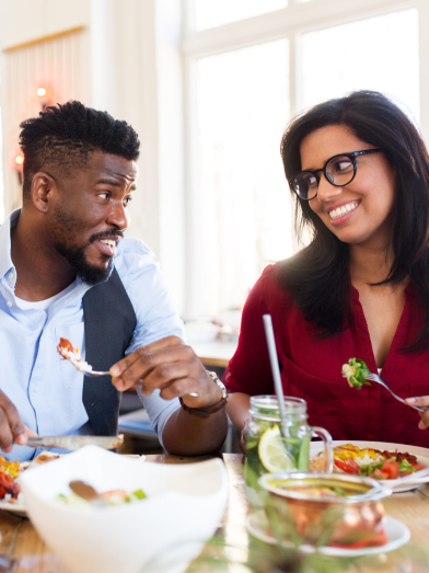 A couple give each other looks while eating dinner