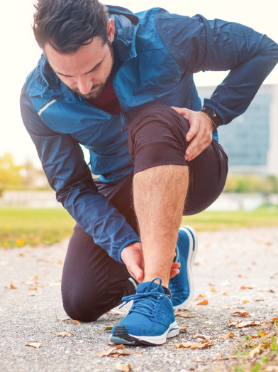 A man is holding his pained foot while exercising.