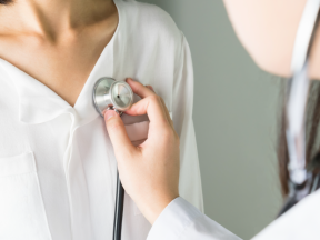 doctor checking patient's heart with stethoscope