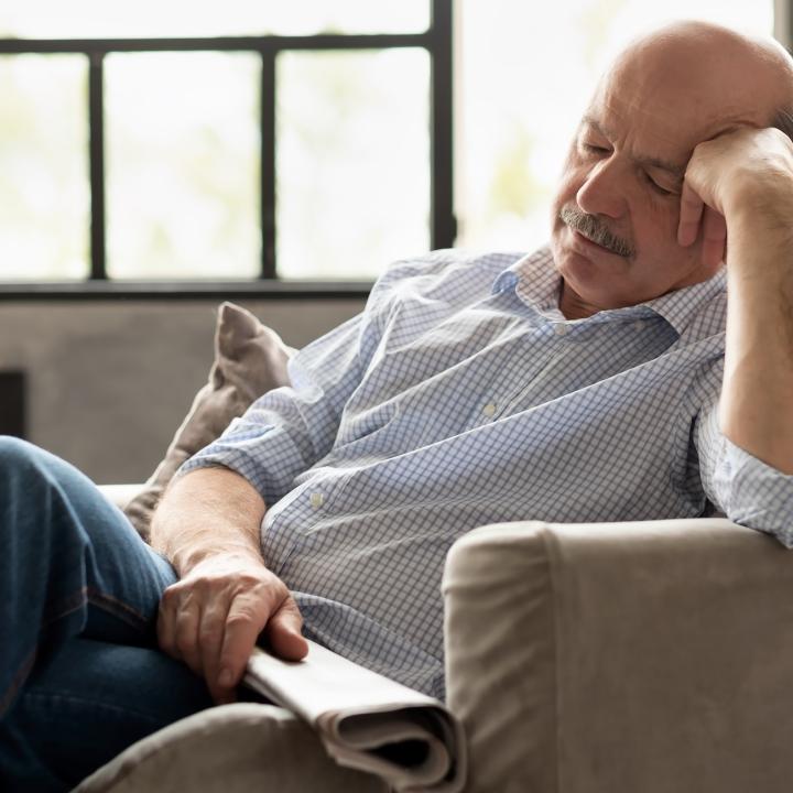 Senior man taking nap in chair